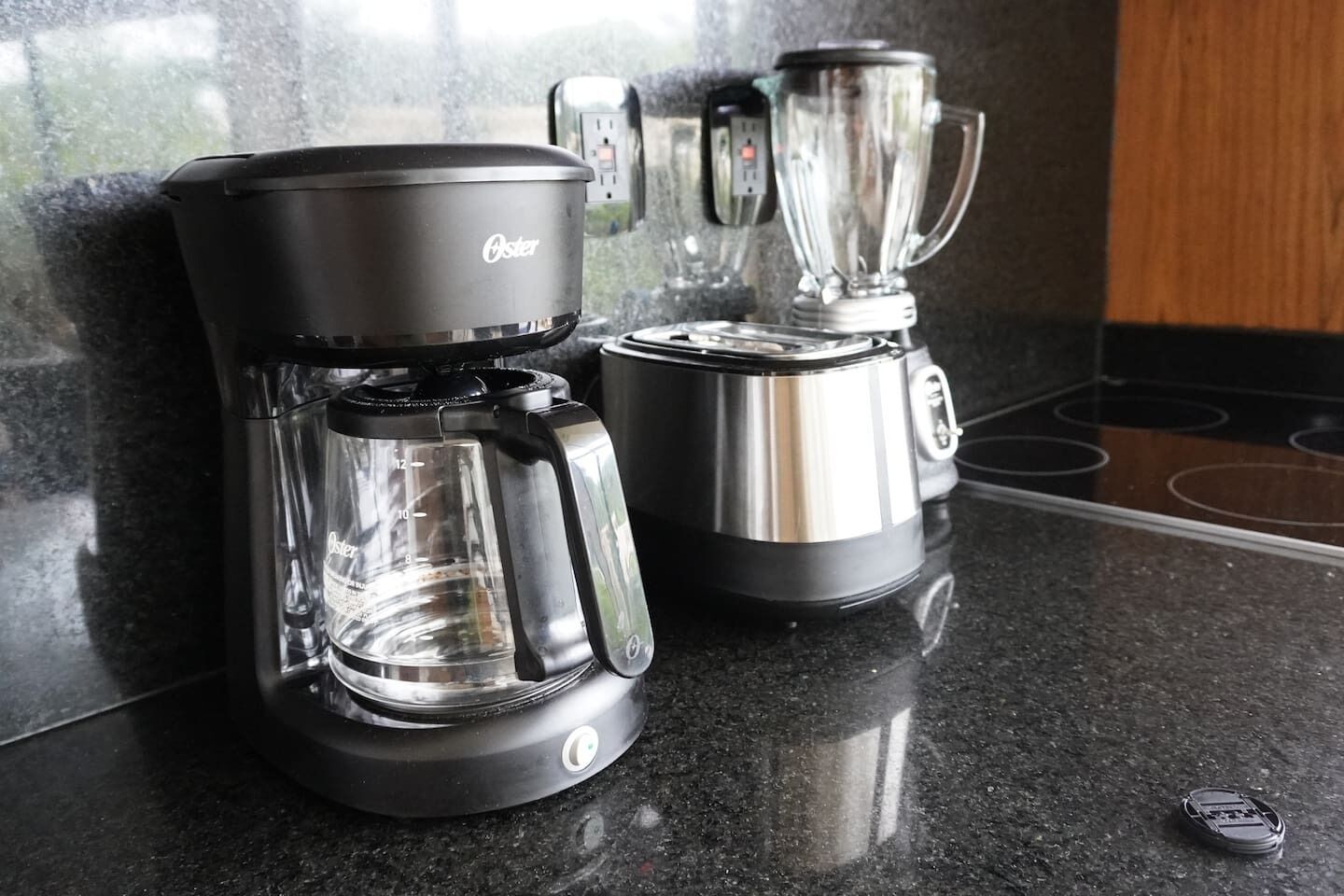 Una macchina per il caffè e un frullatore su un bancone della cucina.