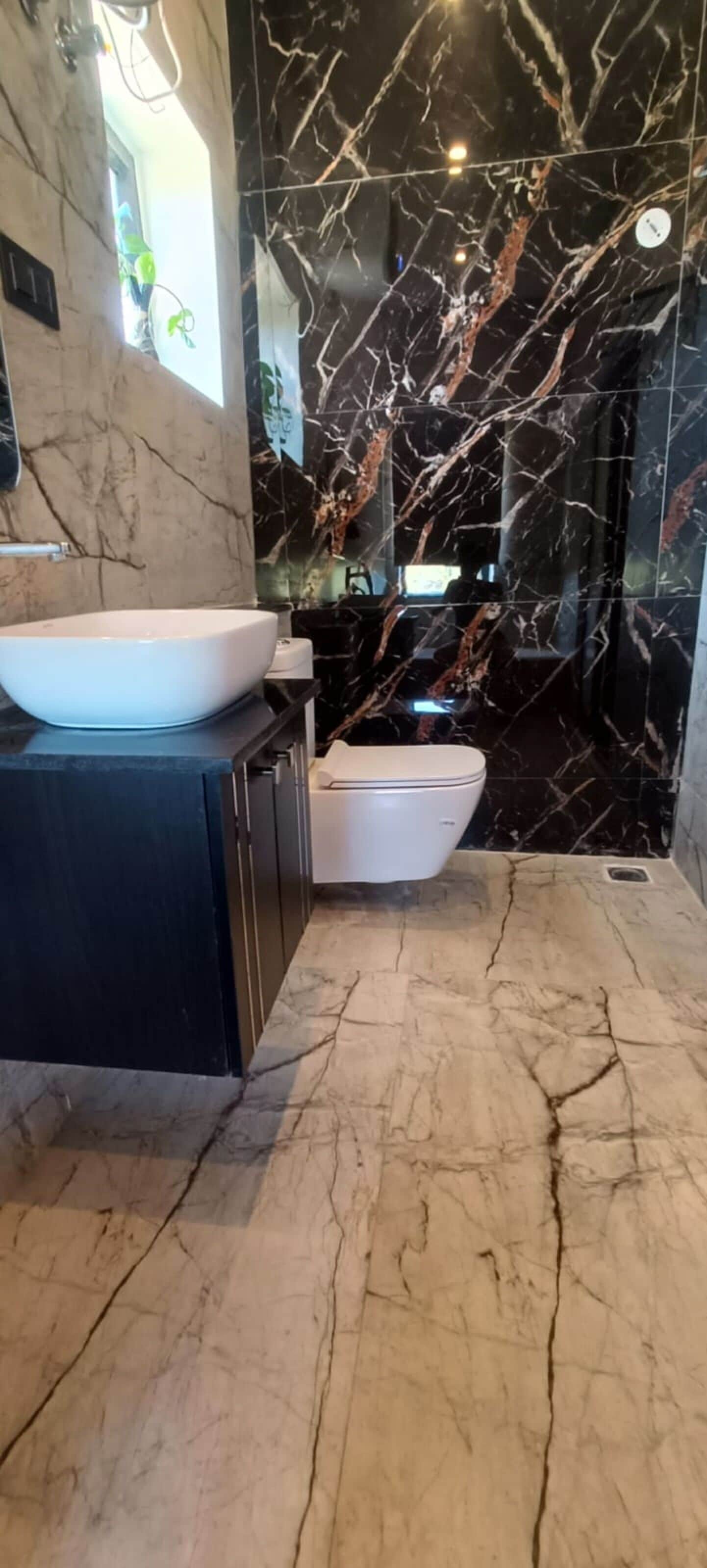 A modern bathroom with a marble vanity, a white sink, and a toilet.