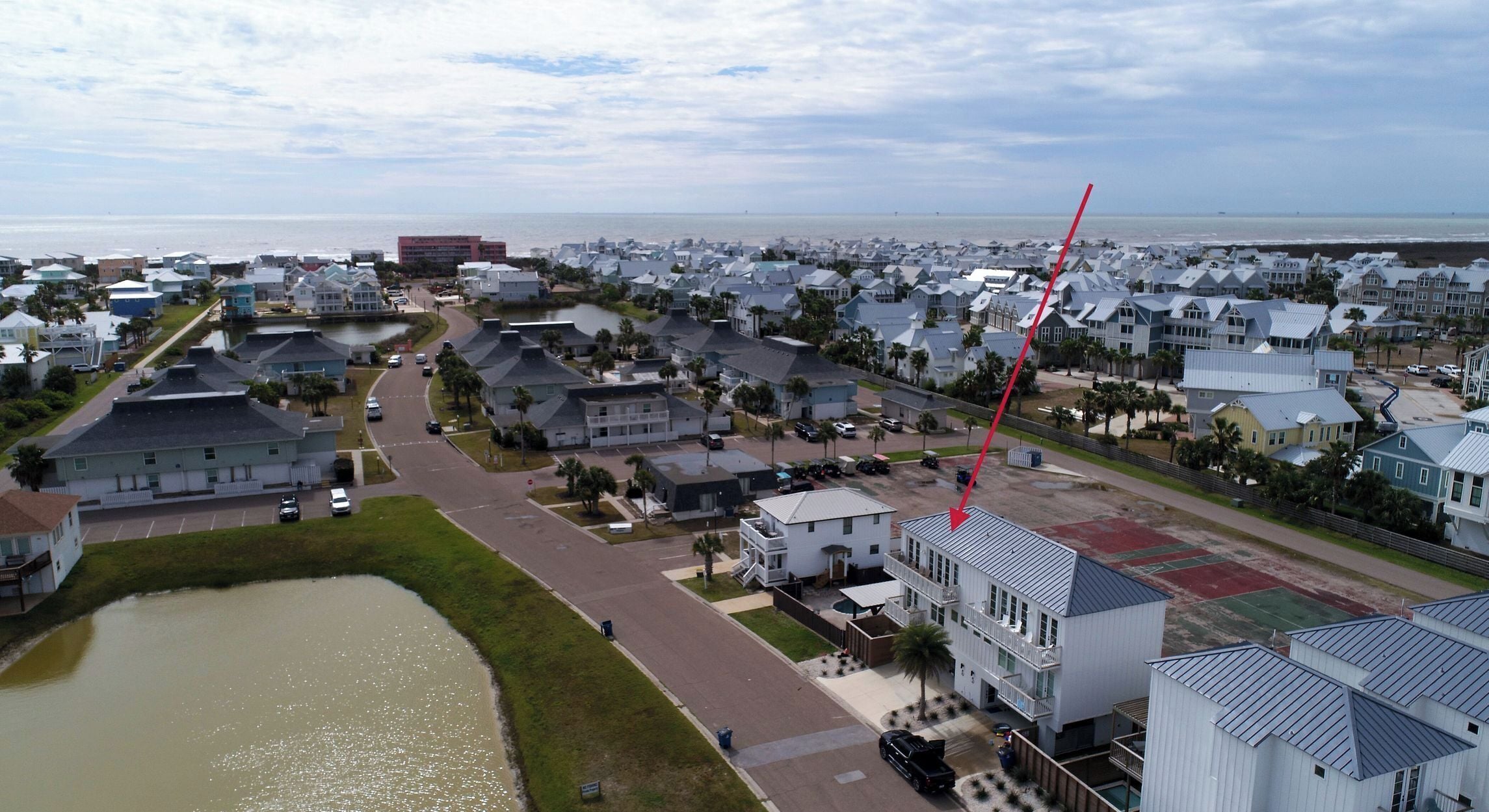 A residential area with houses, a road, and a body of water.