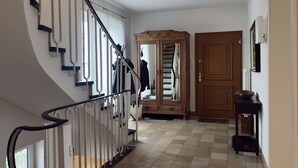 Portaat, joissa on kaide, puuovi ja laatoitettu lattia.
