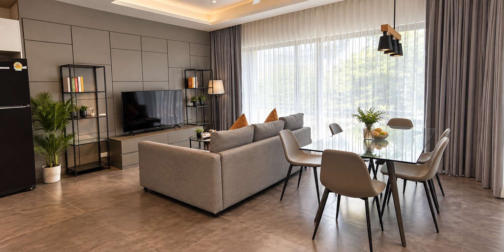 A modern living room with a sofa, TV, and dining area.