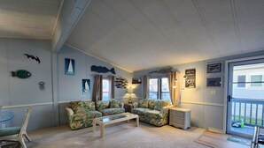 Un salon avec un canapé, une table basse et une lampe.