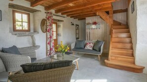A rustic interior with exposed wooden beams, a sofa, wicker furniture, and a staircase. - Beautiful home in Sauliac-Sur-Célé with WiFi (Sauliac-Sur-Célé)