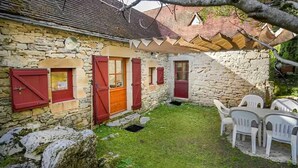 A stone building with red shutters, a small lawn, and white plastic chairs. - Beautiful home in Sauliac-Sur-Célé with WiFi (Sauliac-Sur-Célé)