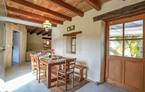 A dining area with wooden furniture, a hanging light fixture, and a view through a window. - Beautiful home in Sauliac-Sur-Célé with WiFi (Sauliac-Sur-Célé)
