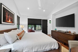A modern bedroom with a large bed, a flat-screen TV, and a ceiling fan. - Zilker Modern + Cowboy Pool - Haven! (Austin)