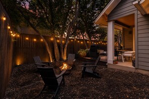 An outdoor patio with a fire pit, seating area, and string lights. - Zilker Modern + Cowboy Pool - Haven! (Austin)