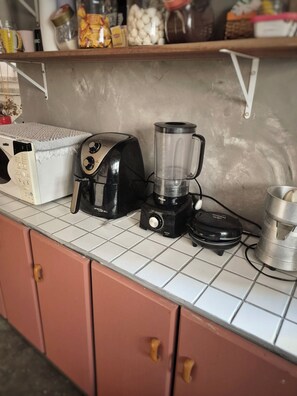 Eine Küchenarbeitsplatte mit einem Toaster, einem Mixer und einem Waffeleisen.