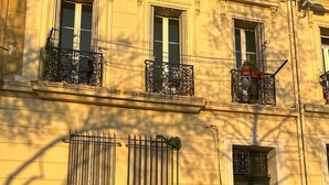A building with multiple windows, some with decorative iron railings, and a green door. - Stunning apartment in Marseille with WiFi (Marseille)
