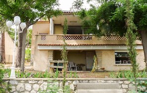 A two-story house with a balcony, stone walls, and a stone wall in the foreground. - Nice home in Carry le rouet with house sea view (Carry le rouet)