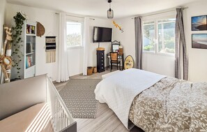 A bedroom with a bed, a desk, a TV, and a window with curtains. - 4 bedroom amazing home in Arles (Arles)