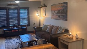 Una sala acogedora con una mesa de comedor de madera, un sofá y un ventilador de techo.