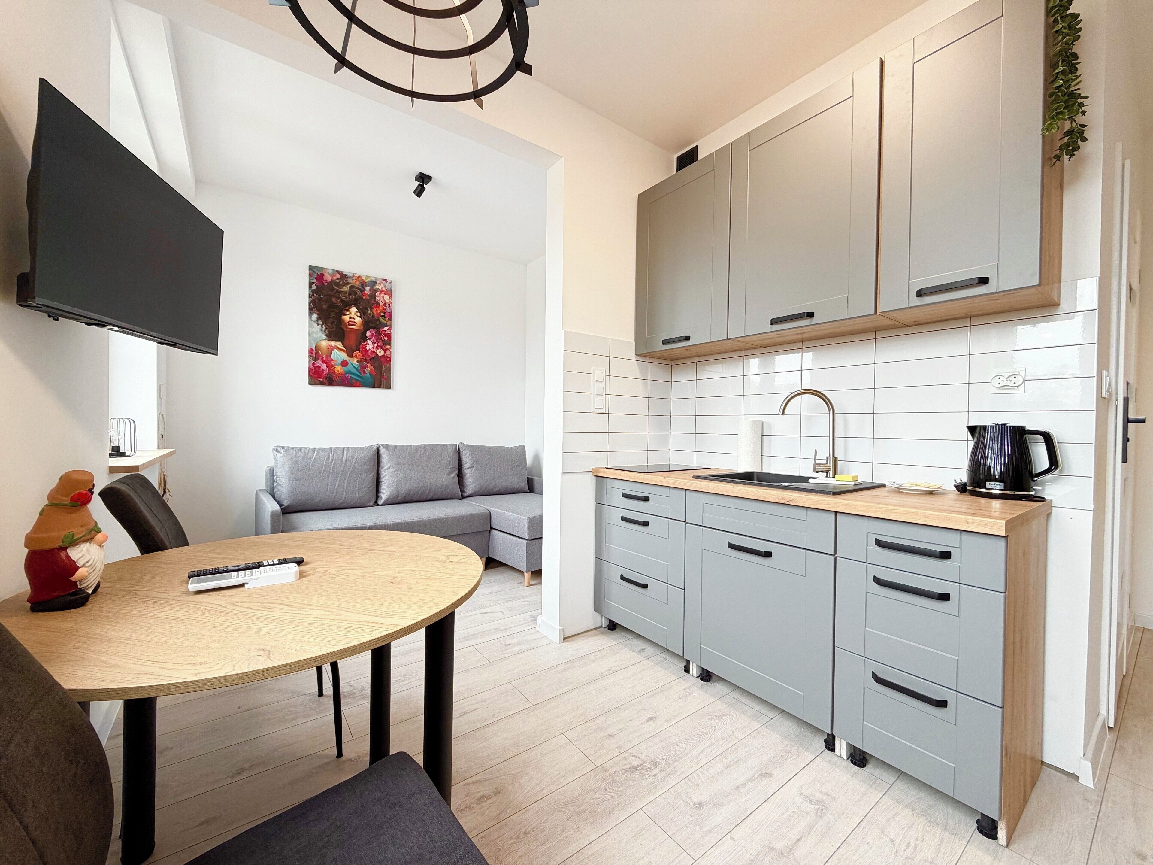 Una cocina moderna con armarios grises, encimera de madera y pileta integrada.