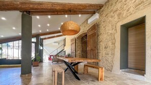 Un interior espacioso con una mesa de madera, banco y lámpara colgante.