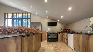 Una cocina moderna con armarios de madera, horno empotrado y un ventanal grande.