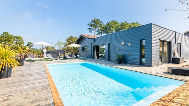 A modern house with a swimming pool, outdoor seating, and a deck. - Villa Mindoya - Villa pour 10, piscine chauffée (Labenne)
