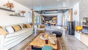 A modern living room with a sofa, coffee table, and decorative items. - Villa Mindoya - Villa pour 10, piscine chauffée (Labenne)