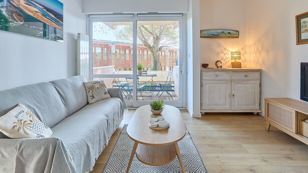 Ein modernes Wohnzimmer mit Sofa, Couchtisch, Schrank und Fernseher.