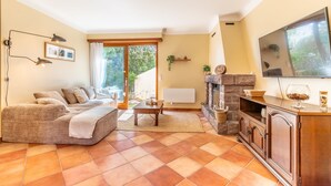 Un salon avec un canapé, une table basse, une cheminée et un téléviseur.