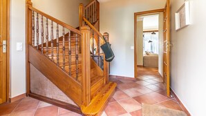 Un escalier en bois, doté d’une rampe et d’un tapis au bas.