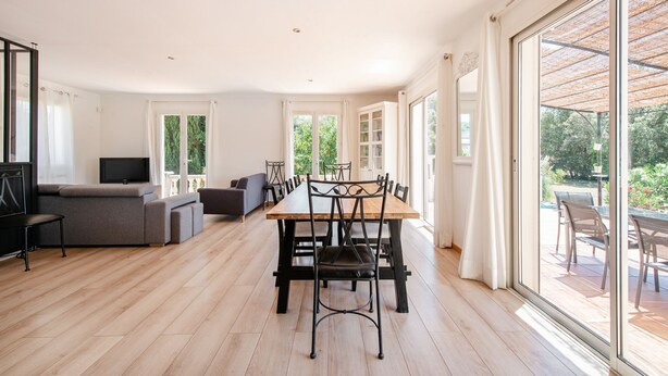 Un grand espace de vie comprenant une table à manger, des chaises, un canapé et un téléviseur.