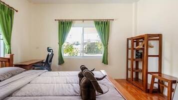 A room with a bed, a desk, and a window with curtains.
