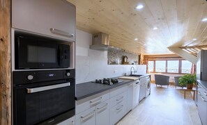Cozinha moderna equipada com micro-ondas, forno e máquina de lavar louça embutida.