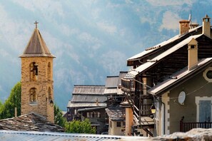 A historic village with stone buildings, wooden balconies, and a church tower. - CASA-Marguerite centre St Véran cosy 3ch (Molines-en-Queyras)