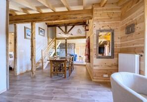 A wooden interior with a dining area, staircase, and a white radiator. - CASA-Marguerite centre St Véran cosy 3ch (Molines-en-Queyras)