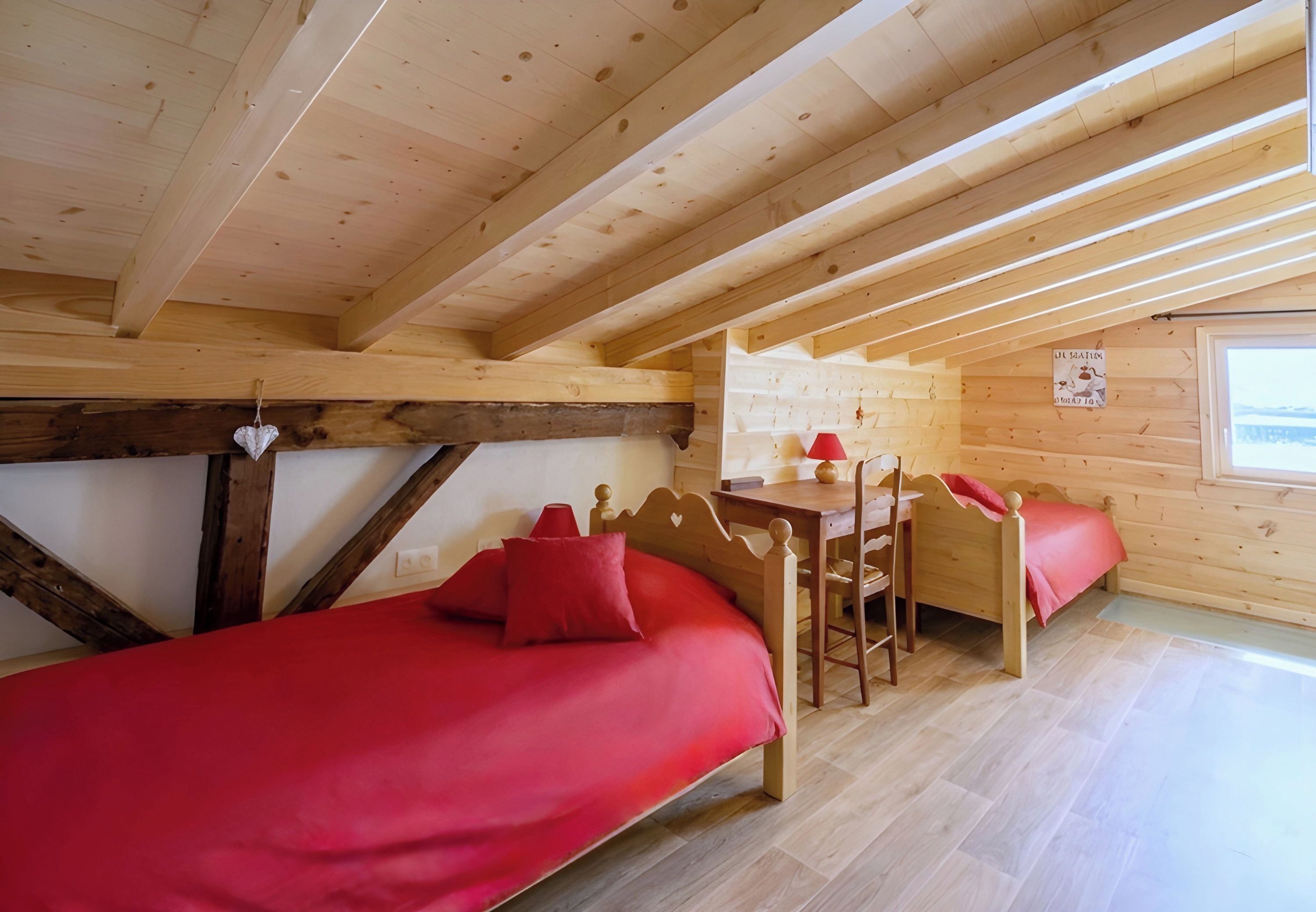 A wooden cabin with a loft bedroom, a dining area, and a view of the outdoors.