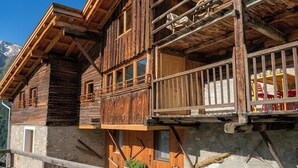 Eine Holzchalet mit Balkon, Stein Fundament und Bergblick.