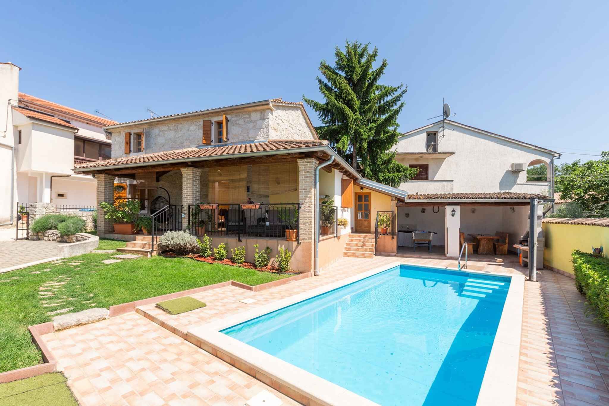 A two-story house with a swimming pool, a covered patio, and a garden.