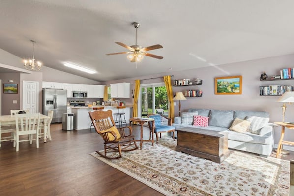 A spacious living room with a sofa, a coffee table, and a dining area with chairs and a table.