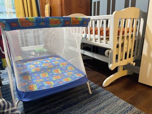 A crib with a mesh canopy and a blue mattress with a pattern.