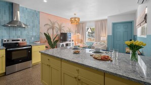 A modern kitchen with a stainless steel range hood, a granite countertop, and a built-in oven. - Stylish 5min Downtown Orlando (Orlando)
