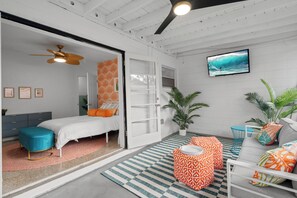 A modern bedroom with a bed, a ceiling fan, a TV, and a large window. - Stylish 5min Downtown Orlando (Orlando)