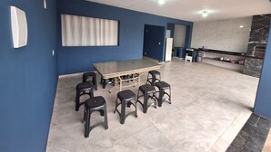 Une cuisine moderne avec un pare-feu en marbre, un coin repas avec une table et des tabourets, et un mur d’accent bleu.