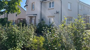 A two-story residential building with a sloped roof, satellite dish, and multiple windows. - Entire Home. 3 bedroom house in Edinburgh suburb (Edinburgh)