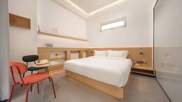 Ein modernes Schlafzimmer mit einem Bett, einem Schreibtisch, zwei Stühlen und einem kleinen Tisch.