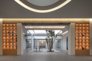 A modern interior with a central glass partition, recessed lighting, and a minimalist design. - La Venta Inn (Tongzhou)