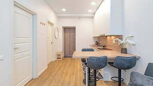 A modern kitchen with a wooden countertop, a sink, and a dining area with bar stools.