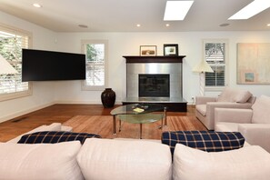 A modern living room with a flat-screen TV, fireplace, comfortable seating, and large windows. - 3 BD Cozy Home in St. Helena,fenced.Monthly rental (Saint Helena)