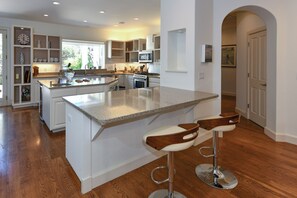 A modern kitchen with an island, bar stools, and a view of the outdoors. - 3 BD Cozy Home in St. Helena,fenced.Monthly rental (Saint Helena)