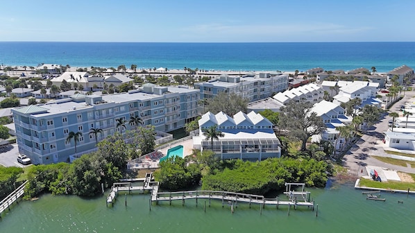 Un hotel costero con varias edificaciones, piscina y muelle.