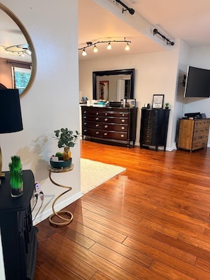A spacious room with hardwood flooring, a large mirror, a dresser, and a television. - World Cup 15 min: Sleeps 10, Pool, Near Airport (Bala Cynwyd)