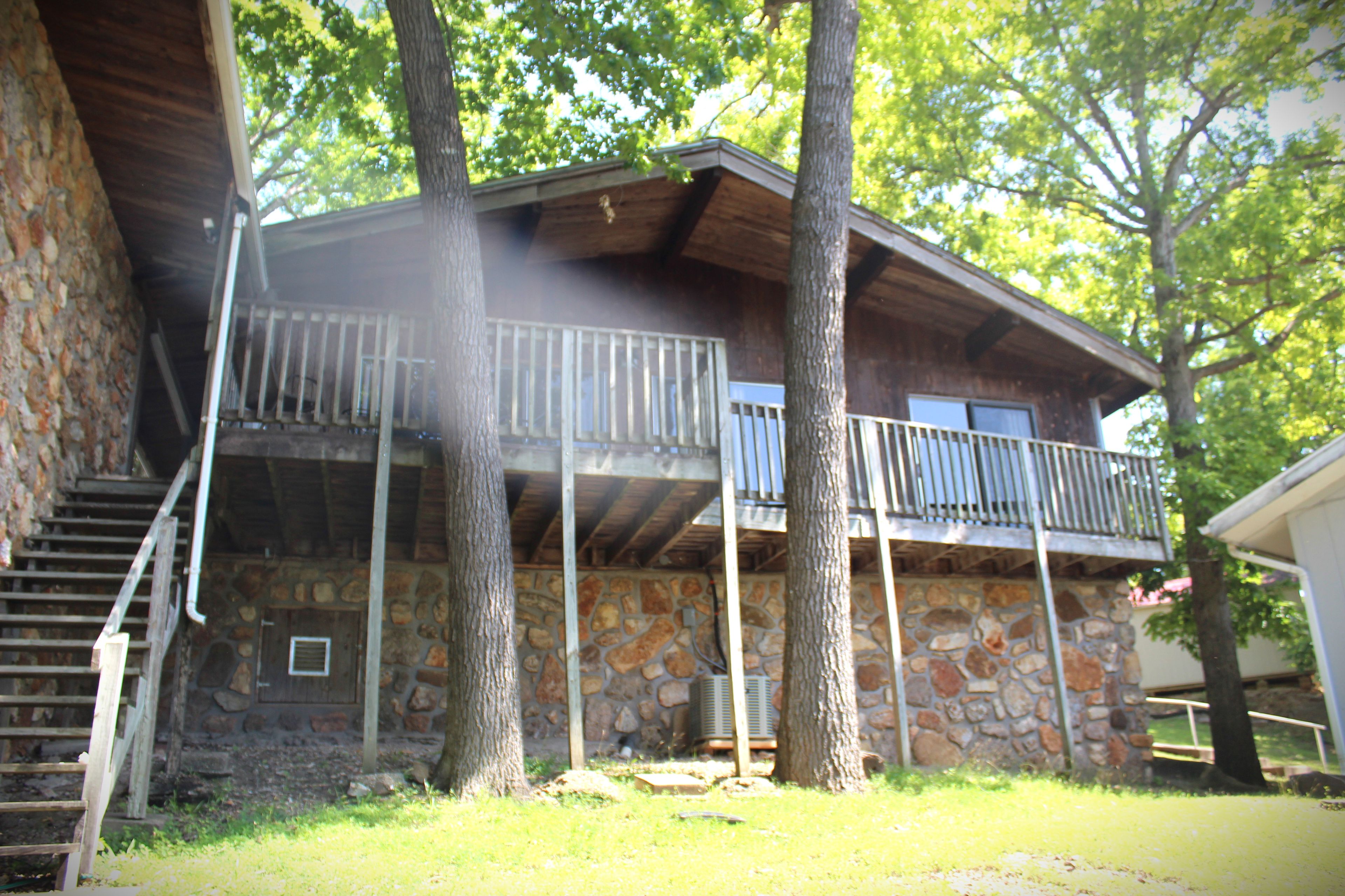 A two-story stone building with a balcony on the upper floor.