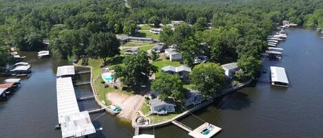 An aerial view of a lakeside property with docks, boats, and cabins.