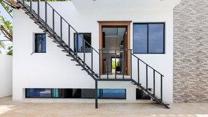 Une maison moderne dotée d’une piscine, d’un escalier et d’une porte donnant sur un espace intérieur.