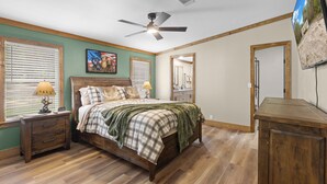 A bedroom with a bed, nightstands, a ceiling fan, a TV, and a wooden dresser. - The Hideaway at Goose Pond Acres- Private Waterfront Retreat (Monticello)