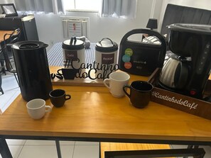 Une table en bois avec du matériel pour préparer du café et des tasses.